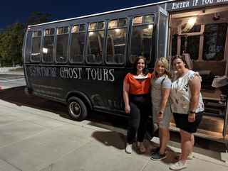 Three guests beside the Grimm Ghost Tours bus in Salt Lake City
