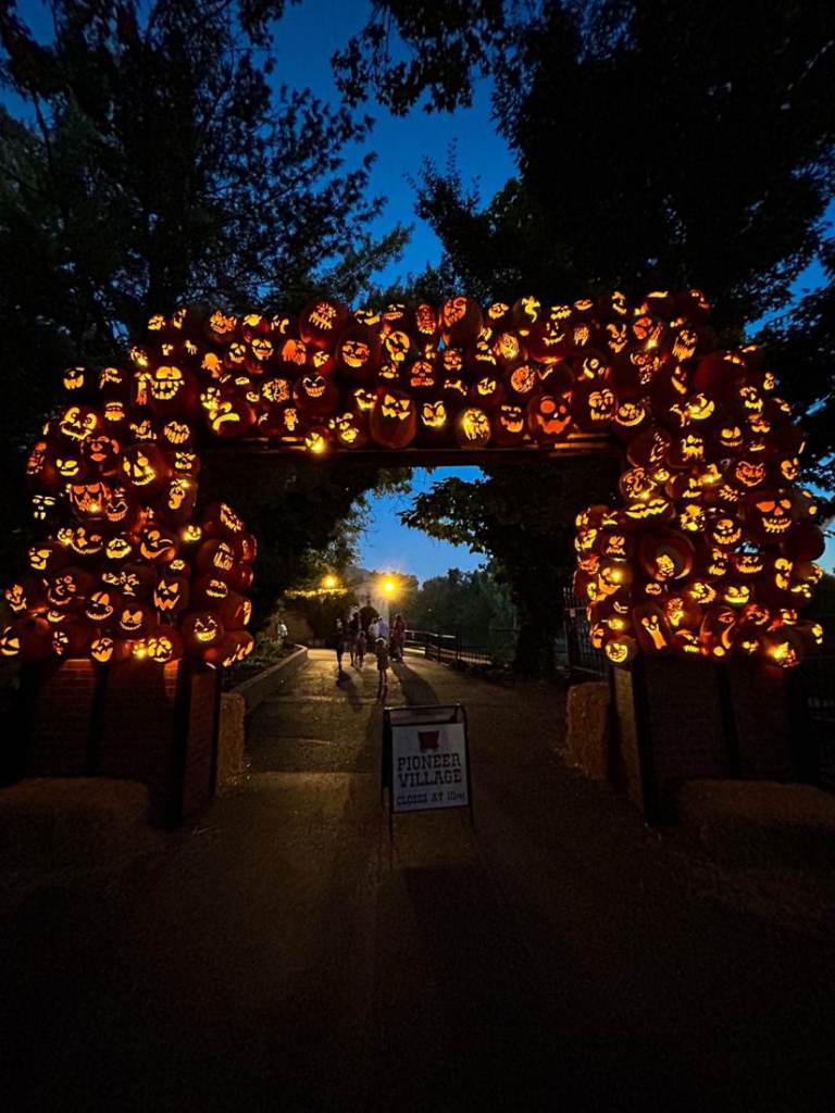 Glowing jack-o'-lantern arch at Pioneer Village during Lagoon Frightmares