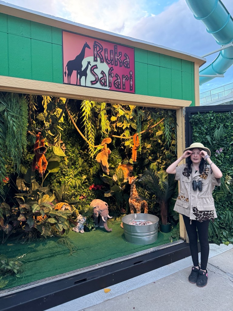 Ruka Safari Treat Street booth with jungle decorations, stuffed animals and a costumed attendant at Lagoon Frightmares.