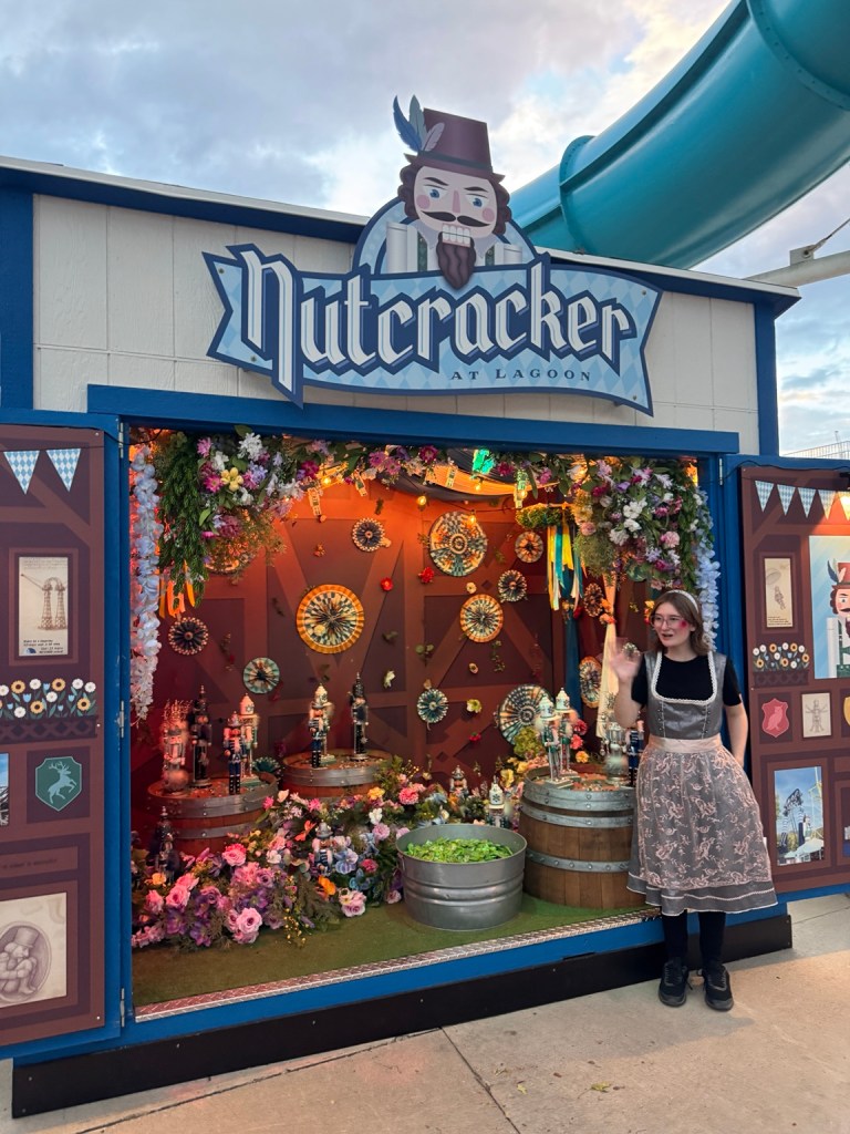 Nutcracker Treat Street booth with flowers, nutcrackers and a costumed attendant at Lagoon Frightmares.