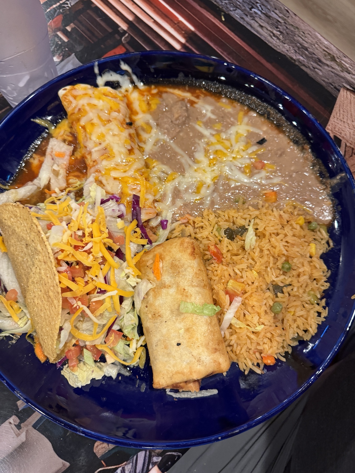 Large Mexican combination plate with taco, enchilada, rice, and refried beans
